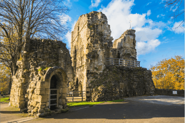 The medieval ruins of Knaresborough Castle on the hill above the River Nidd, framed by autumn trees