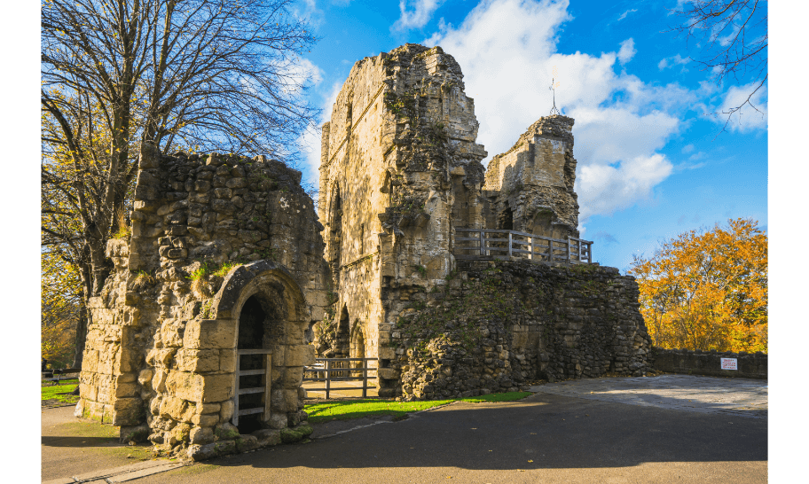The medieval ruins of Knaresborough Castle on the hill above the River Nidd, framed by autumn trees